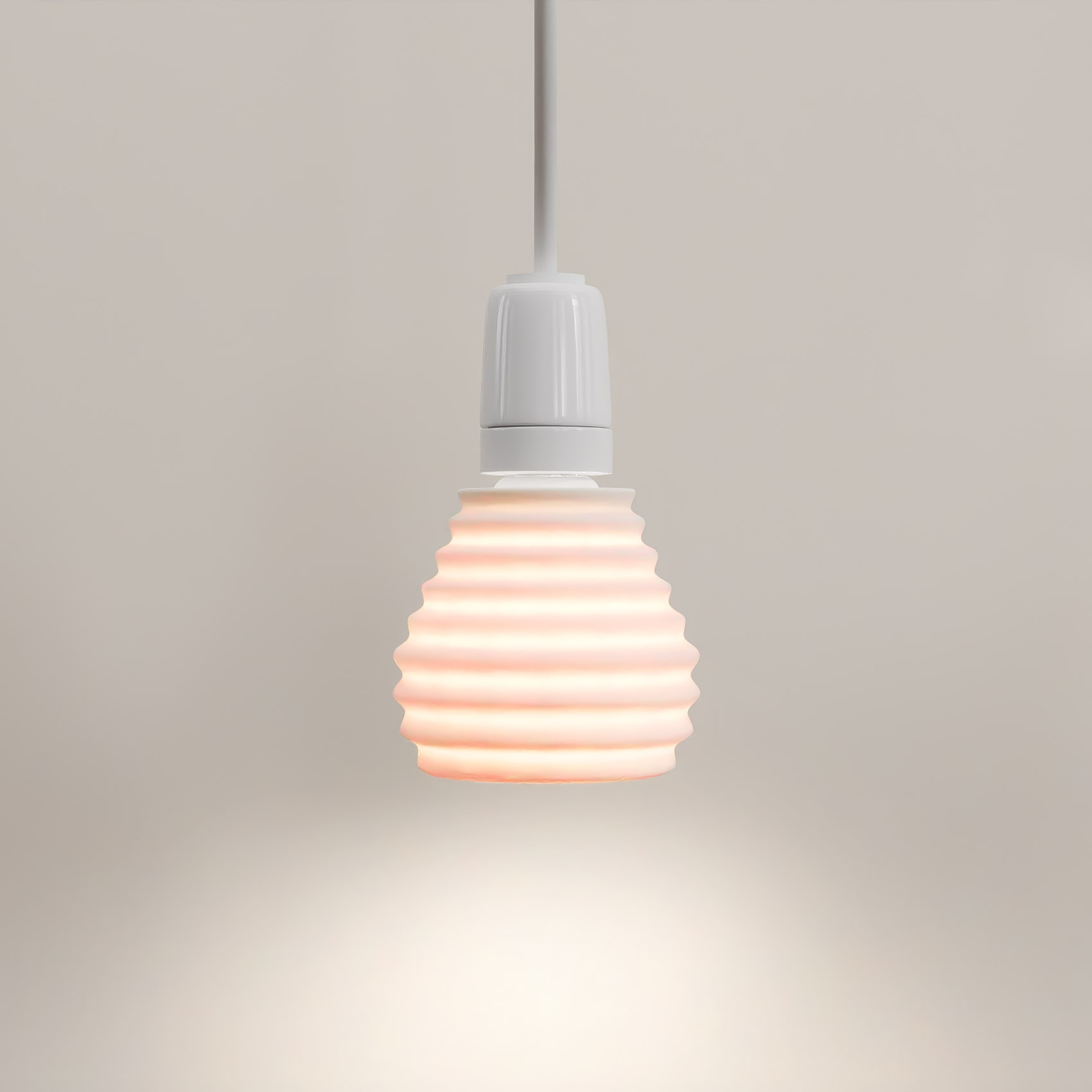 Shell pendant, lit, against a plain wall